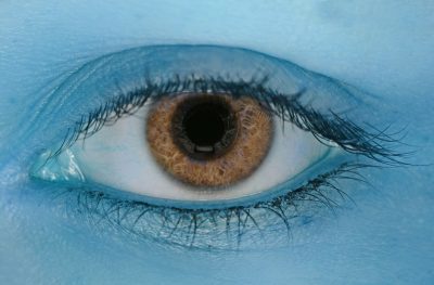 Cuida tu salud mientras trabajas en casa. Foto de u ojo con fondo azulado.
