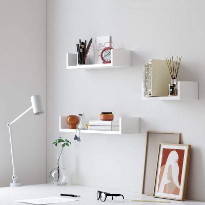 Dónde poner tu oficina encasa: baldas blancas en una pared, sobre una mesa de trabajo blanca.