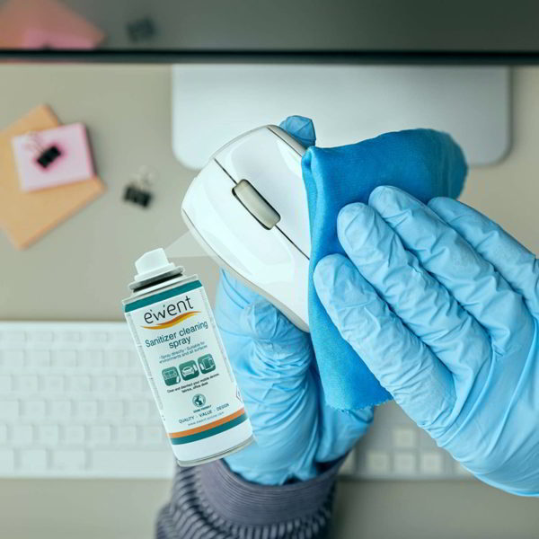 Manos con guantes azules de limpieza limpiando un ratón con un producto desinfectante. Cómo limpiar y desinfectar los equipos electrónicos 